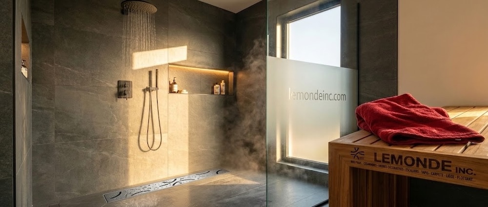 Gros plan d'une grille de drain linéaire à motif floral en acier inoxydable brossé sur grande céramique beige